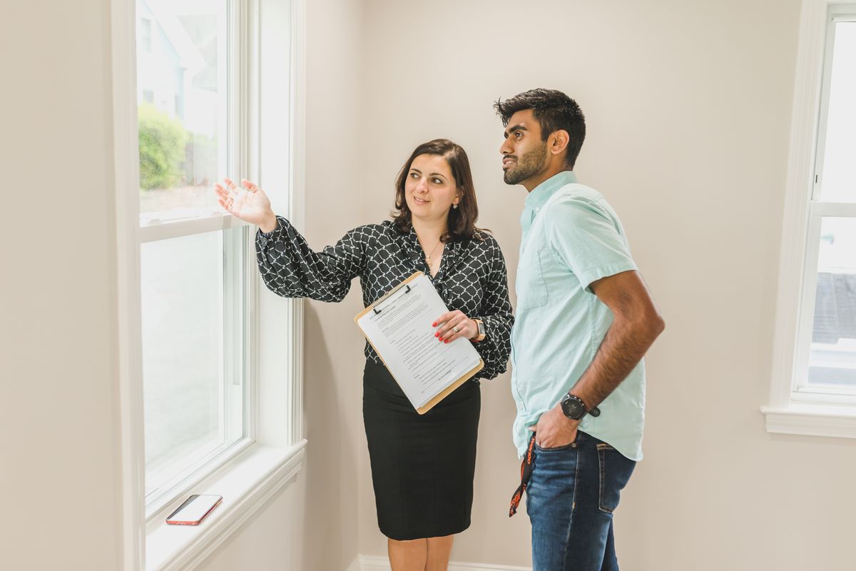 A REALTOR discussing a home valuation Red Deer clients can trust, walking through the home with a homeowner.