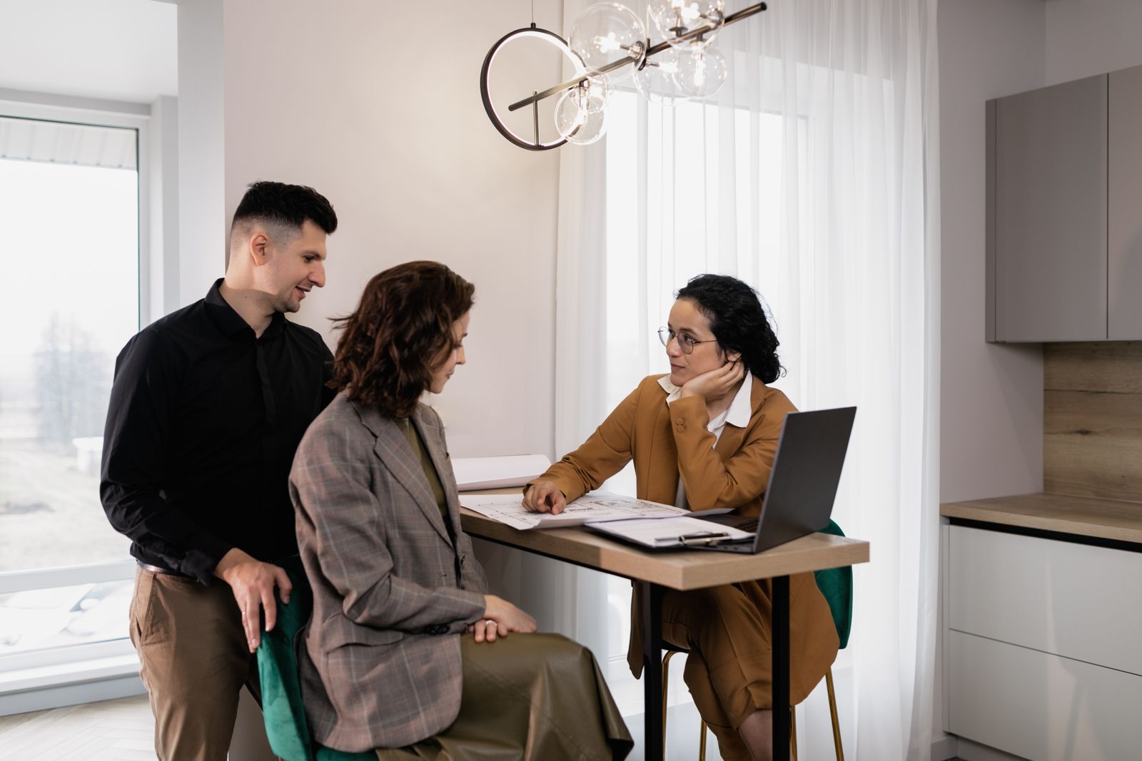 Couple sitting at a table going over home buying and selling costs with their REALTOR in Central Alberta