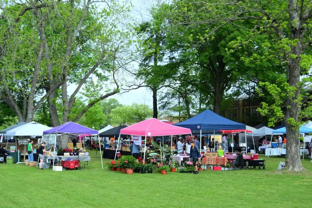 Outdoor farmers market with vendor tents, like the Lacombe Farmers Market