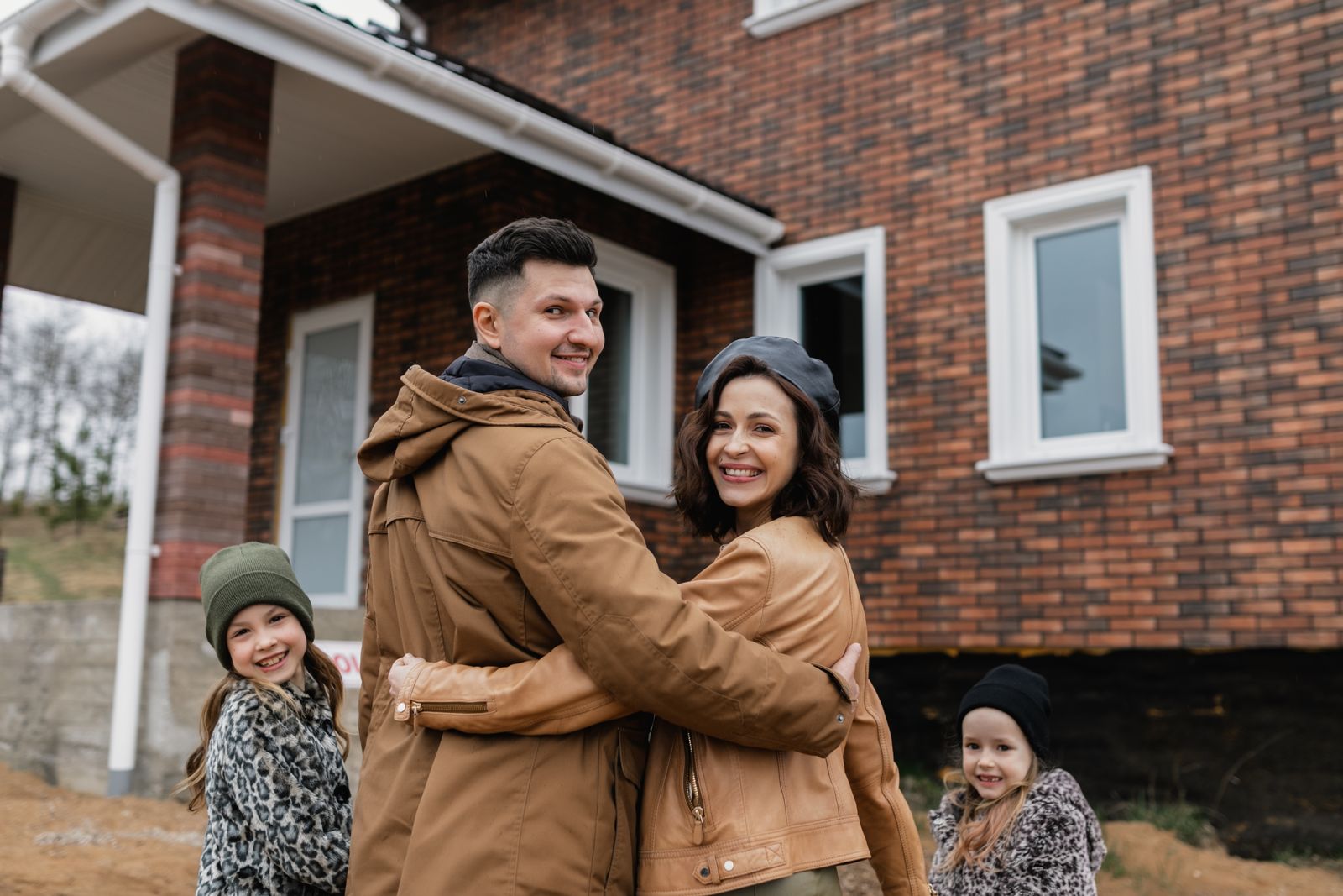 Family standing in front of their new home, Lacombe real estate market