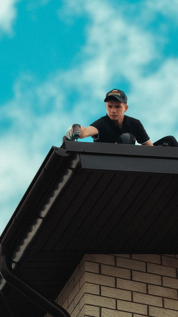 Roofer inspecting shingles on a house roof before an Alberta winter